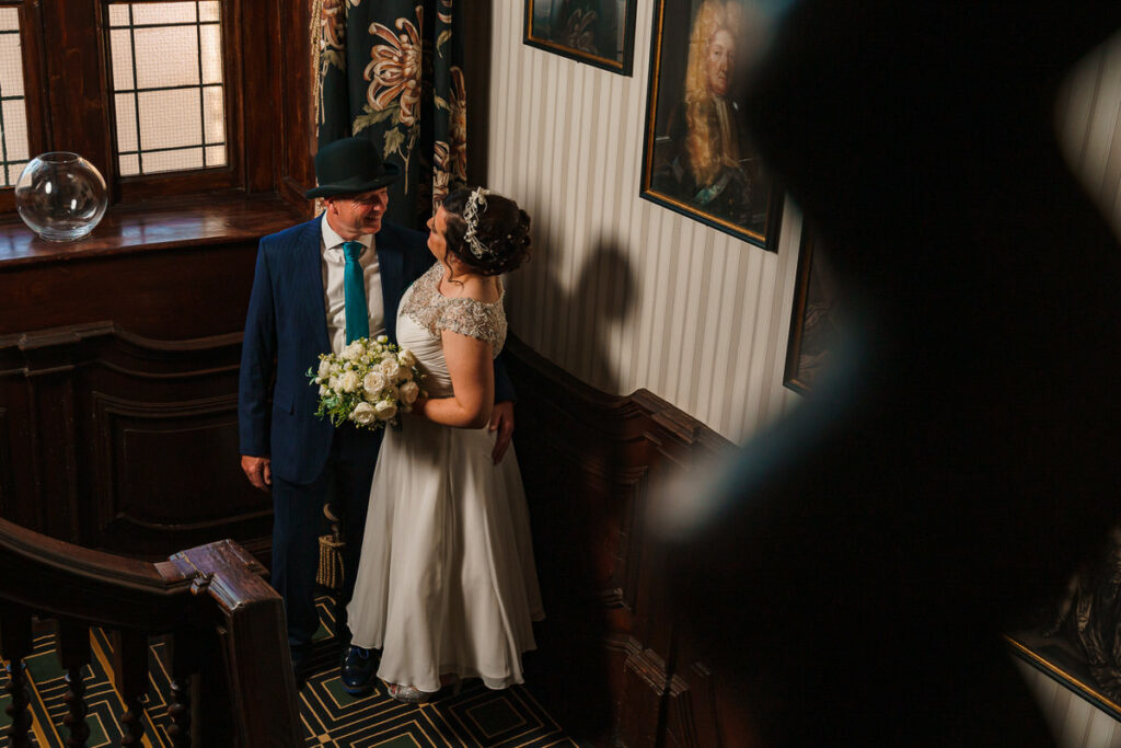 Bride and Groom embrace on stairway at The Bedford Swan Hotel