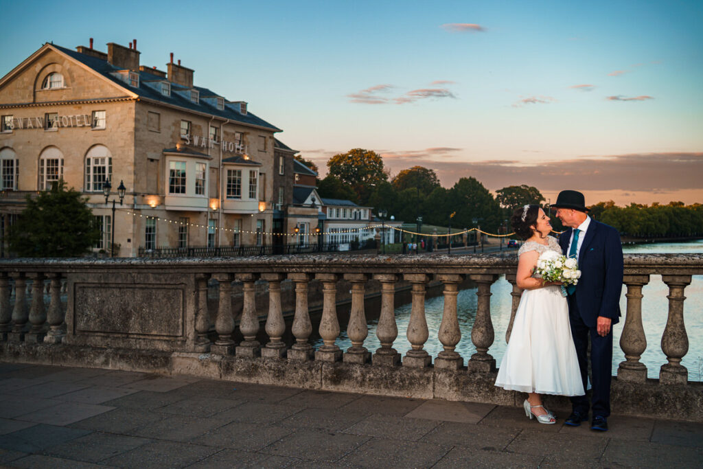 Bride and Groom stood on a bridge over the River Ouse at The Bedford Swan Hotel