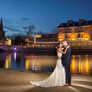 Bride and Groom embrace outside The Bedford Swan Hotel at night